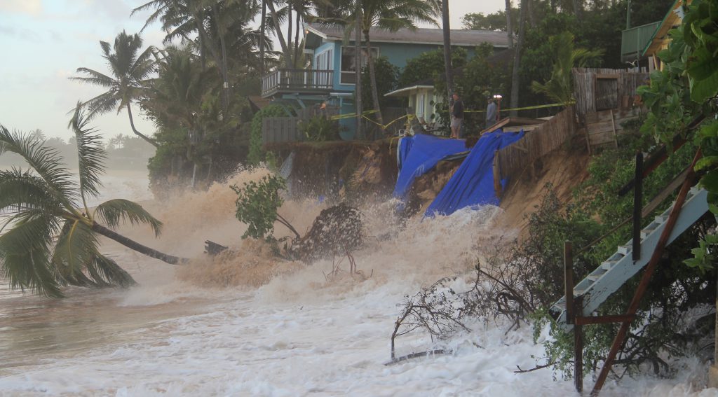 Homeowners on the North Shore of Oahu observe the surf eroding the beach in front of their homes.