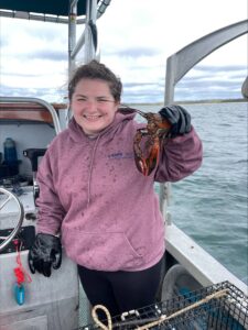 Lindsey Smitty Smith, a senior lab specialist with researcher Jeff Shields at the Virginia Institute of Marine Science, collects lobsters for microbiome research from a boat in September 2024. Image credit: Sarah Koshak