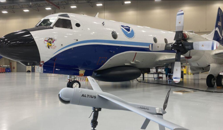 The Altius-600 uncrewed aircraft system demonstration model appears with Hurricane Hunter NOAA WP-3D Orion, known as “Miss Piggy,” at NOAA’s Aircraft Operations Center in Lakeland, Florida, during an uncrewed aircraft system flight test on May 25, 2022. The Altius was recognized by the 2024 Guinness World Records book for the longest endurance flight inside a tropical cyclone by an uncrewed aircraft. (Image credit: NOAA/Aircraft Operations Center)